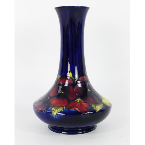 1709 - A Moorcroft pottery vase with pansy decoration, of squat form with slender flared neck, 26cm high.