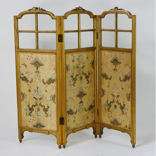 1723 - A gilt wood triple panel folding screen, of arched outline with ribbon tied decoration, with silk pa... 