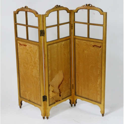 1723 - A gilt wood triple panel folding screen, of arched outline with ribbon tied decoration, with silk pa... 