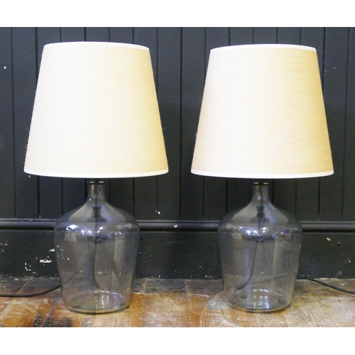 1602 - A pair of clear glass  table lamps, of demi-john form, complete with shades, overall height, 65cm. (... 