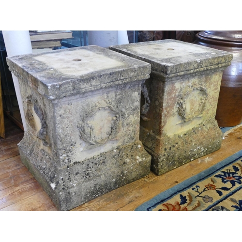 1671 - A pair of reconstituted stone plinth with wreath decoration to the sides, 45cm wide, 51cm high.