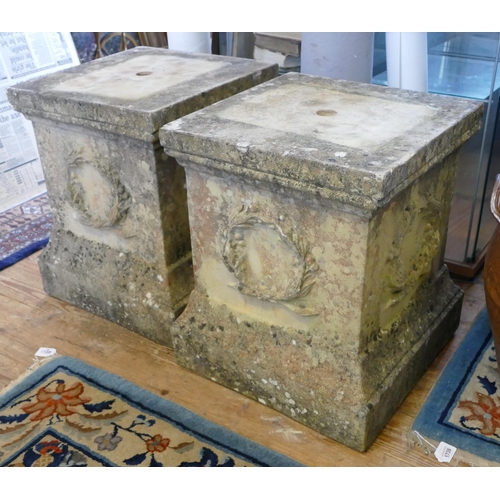 1671 - A pair of reconstituted stone plinth with wreath decoration to the sides, 45cm wide, 51cm high.