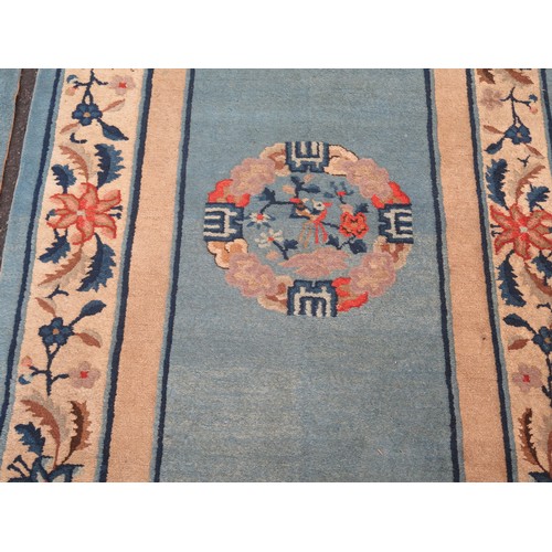 1738 - A Chinese rug, the powder blue field with central mons, enclosed by a floral meander border, 180 x 9... 