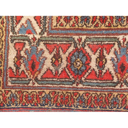 1737 - A Persian design runner, the beige field with rows of lozenge medallions and flowerheads, enclosed b... 