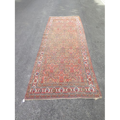 1737 - A Persian design runner, the beige field with rows of lozenge medallions and flowerheads, enclosed b... 