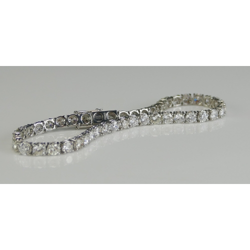 1 - A Platinum and Diamond Tennis or Line Bracelet set with 34 c. 3.t6mm brilliant round cuts weighing c... 