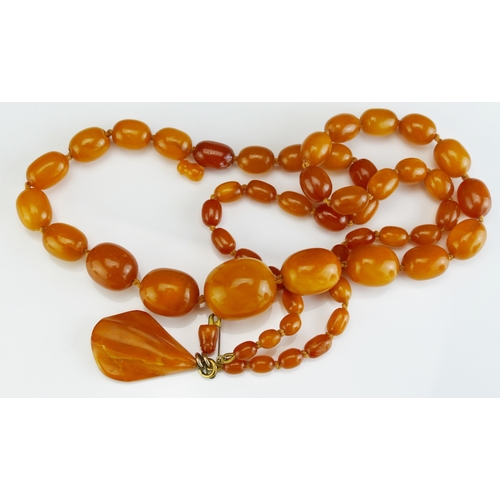 184 - An Amber Bead Necklace and pendant, largest bead 25.6x21.8mm, 82.5cm (32.5