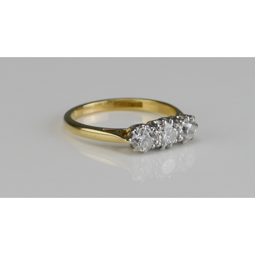 205 - An 18ct Gold and Diamond Three Stone Ring, c. 4.4mm principal and 4.2mm shoulders in a platinum sett... 