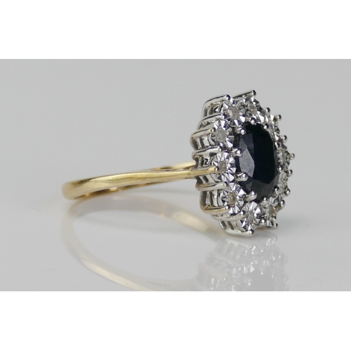 217 - A 9ct Gold, Sapphire and Diamond Cluster Ring, c. 9x7.1mm principal stone surrounded by illusion set... 