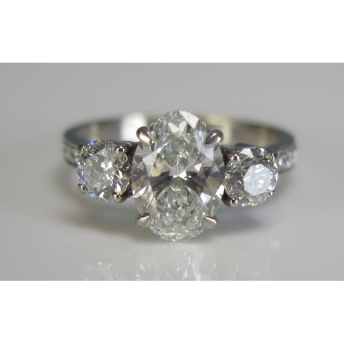 308 - An 18ct white gold three stone diamond ring, the central 2ct laboratory grown diamond flanked by two... 