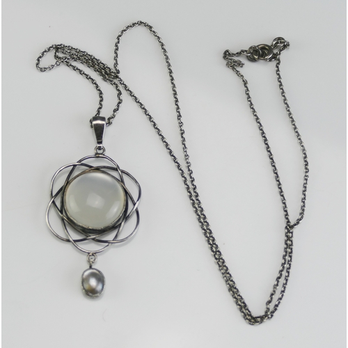 43 - An Arts & Crafts Moonstone and Blister Pearl Pendant in a precious white metal setting (47.6mm drop)... 