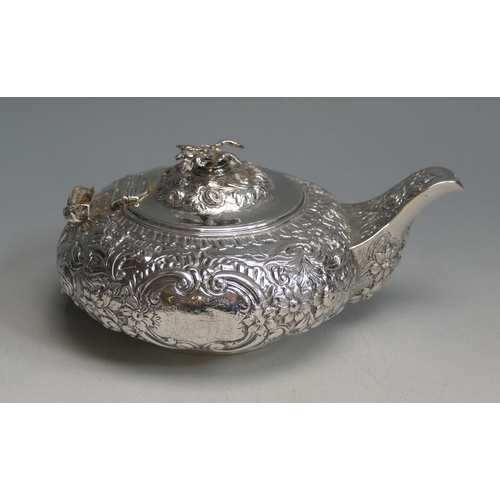 502 - A George IV silver teapot, maker Thomas Baker London, 1823, crested, of circular form with embossed ... 