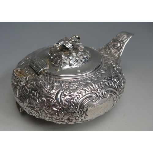 502 - A George IV silver teapot, maker Thomas Baker London, 1823, crested, of circular form with embossed ... 