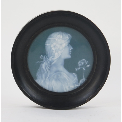 1739 - A 19th century pate sur pate circular panel of a neo-classical maiden holding a flower, contained in... 