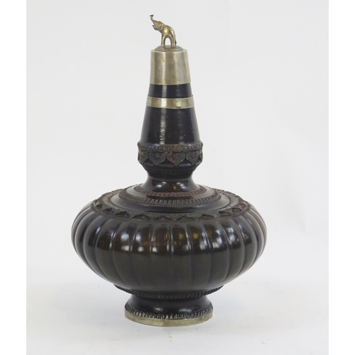 1784 - A Mughal turned and carved hardwood and white metal mounted bottle, of squat bulbous form, with tape... 