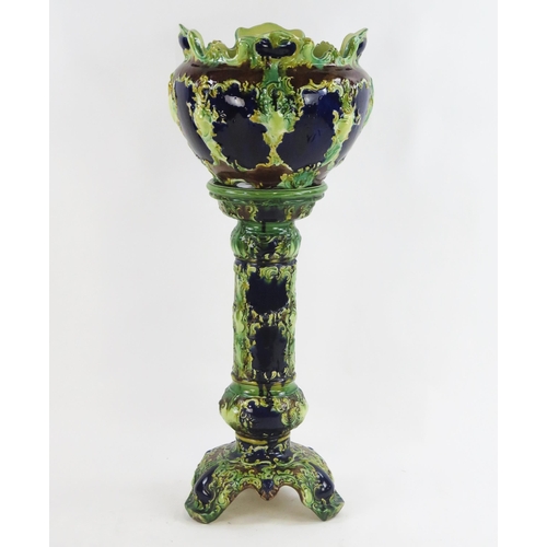 1852 - A large Victorian majolica style jardiniere and stand, with scroll and floral moulded decoration, ov... 