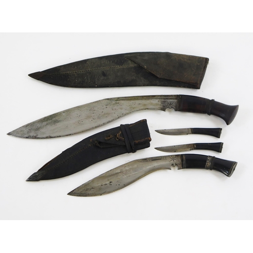 1904 - A traditional kukri with 34cm curved blade in leather sheath, togther with a smaller kukri contained... 