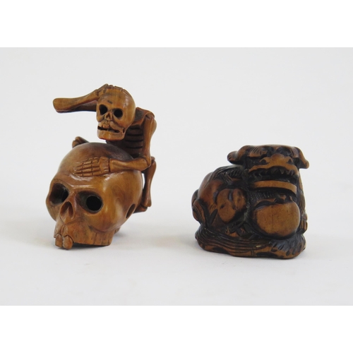 1922 - A Carved boxwood netsuke in the form of a skeleton climbing on a skull, signed, 5cm high, together w... 