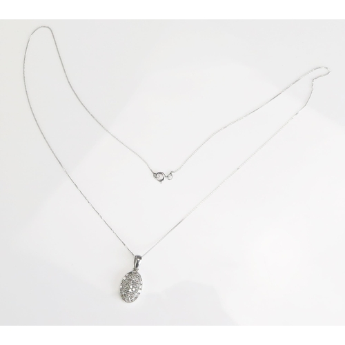 290 - A diamond encrusted oval pendant, in 9ct white gold mount and chain, length of chain 225mm.