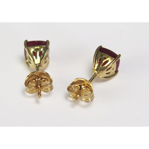 294 - A pair of cushion cut ruby ear studs, approx 2ct, in9ct gold mounts.