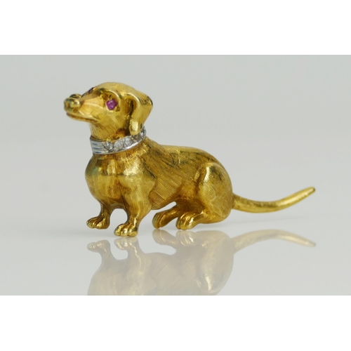 78 - An 18ct Gold Dachshund Brooch with a ruby eye and diamond set collar in a white metal setting, 43mm ... 