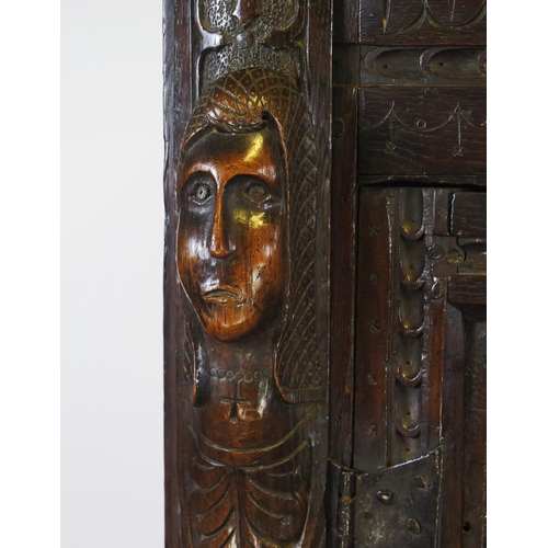 800A - A 17th century carved oak marriage/livery cupboard, with dentil moulded cornice, above a pair of hea... 