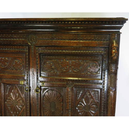 800A - A 17th century carved oak marriage/livery cupboard, with dentil moulded cornice, above a pair of hea... 