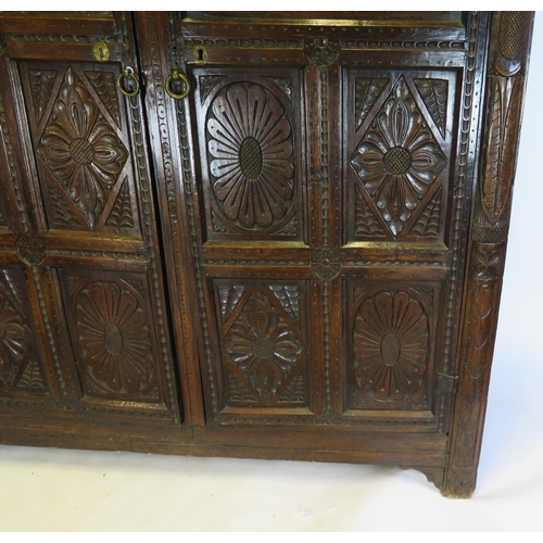 800A - A 17th century carved oak marriage/livery cupboard, with dentil moulded cornice, above a pair of hea... 