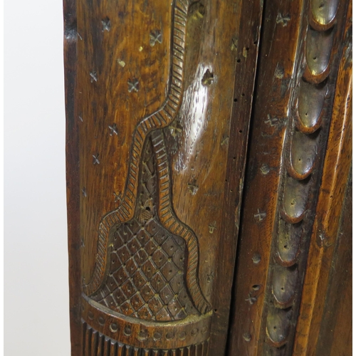 800A - A 17th century carved oak marriage/livery cupboard, with dentil moulded cornice, above a pair of hea... 