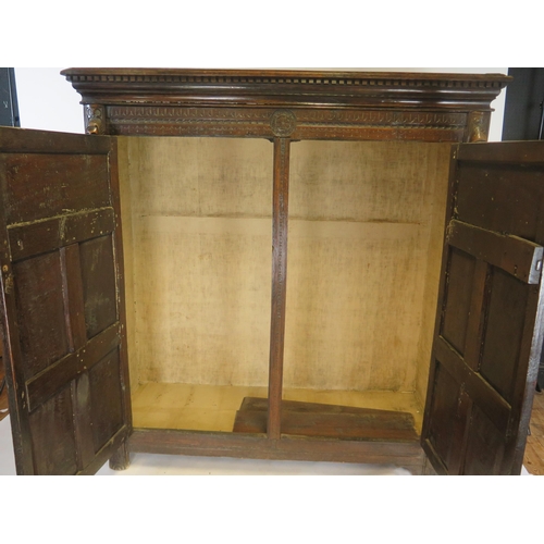 800A - A 17th century carved oak marriage/livery cupboard, with dentil moulded cornice, above a pair of hea... 