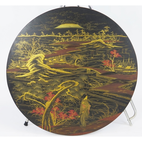 1848 - A Japanese lacquered circular table top, decorated with young woman in an extensive river landscape ... 