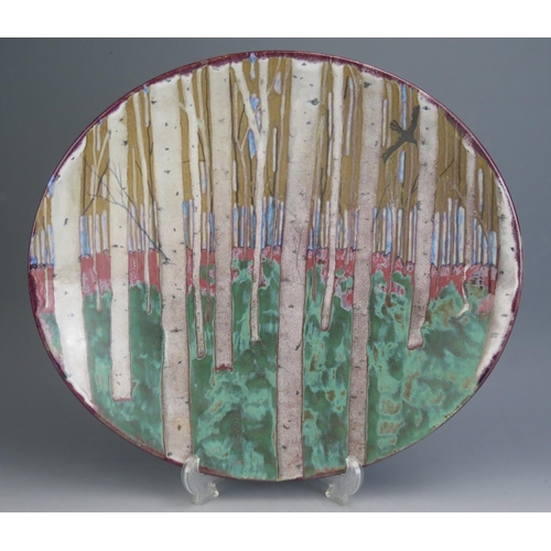 1064 - A Petra Tilley Studio Pottery Stoneware Oval Shallow Dish decorated with stylized trees and a bird i... 