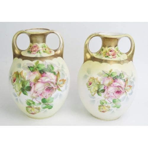 1082 - A pair of German porcelain twin handled vases, with rose pattern decoration, 18cm high.