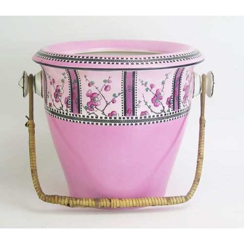 1083 - An Edwardian pottery slop pail and cover, with wicker handle, and printed floral decoration.