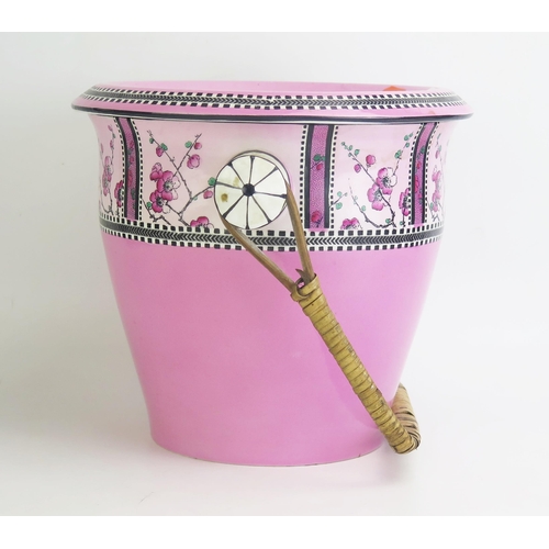 1083 - An Edwardian pottery slop pail and cover, with wicker handle, and printed floral decoration.