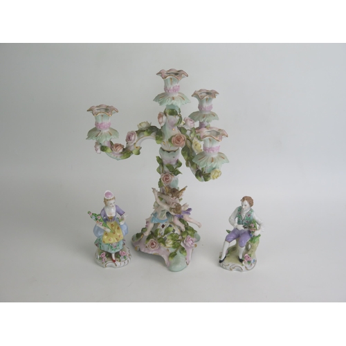 1085 - A continental porcelain three- branch candelabra with floral encrusted and cherub decoration 32cm hi... 