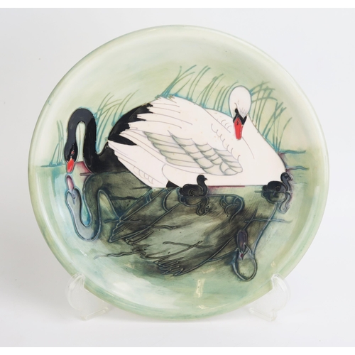 1104 - A Moorcroft pottery plate decorated with swans and signets, 26cm diameter No 329/350, impressed mark... 