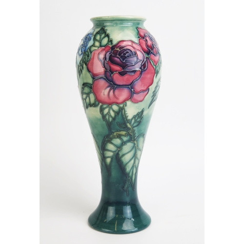 1111 - A Moorcroft pottery vase of slender baluster form, decorated with rose pattern decoration, 27.5cm hi... 