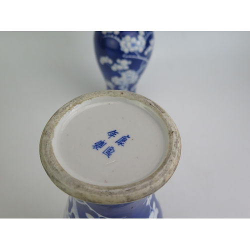 1146 - A pair of Chinese porcelain vases of baluster form with flared rims with blue and white prunus decor... 