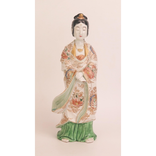 1148 - A Japanese porcelain figure of a woman in traditional robes, with enamel decoration heightened in gi... 