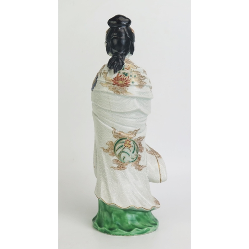 1148 - A Japanese porcelain figure of a woman in traditional robes, with enamel decoration heightened in gi... 