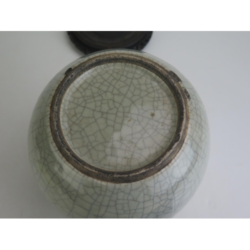 1162 - A Chinese celadon crackle glazed pot, of ovoid form, on a circular wood base, 23cm high, Qing Dynast... 