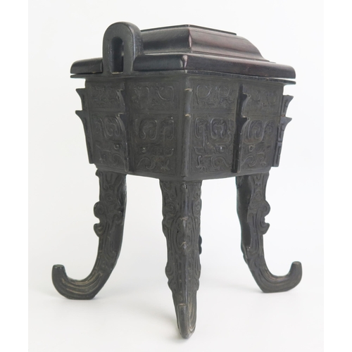 1169 - A Chinese bronze censer and cover, of rectangular outline with archaic designs, having a domed wood ... 