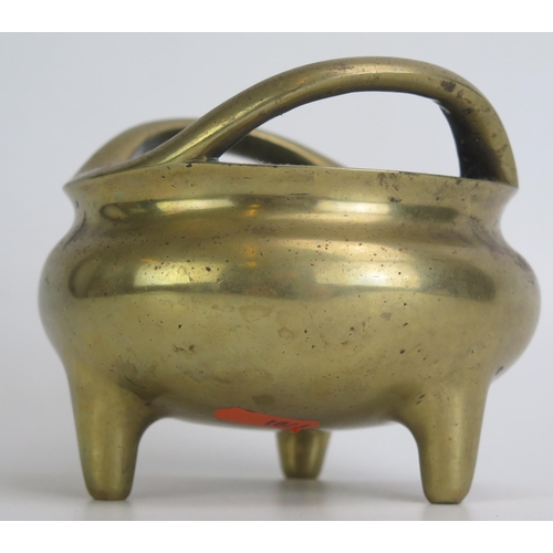 1172 - A Chinese bronze tripod censer, of circular form with swept handles, on three peg feet, bears apocry... 