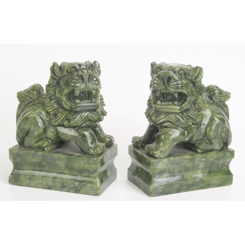 1174 - A pair of Chinese jade style figures of temple lions, mounted on rectangular plinth bases12cm high, ... 