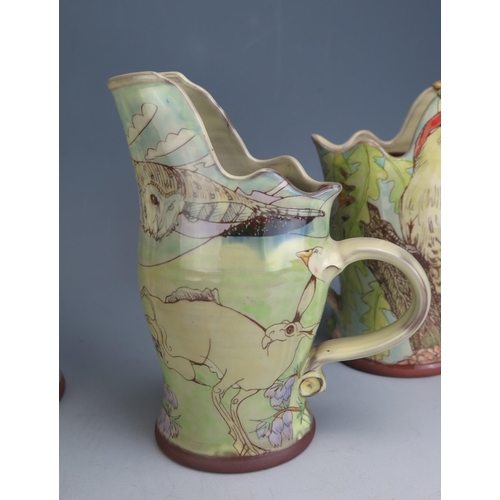 1206 - A Near Pair of Studio Pottery Terracotta Jugs, one decorated with a red squirrel and green woodpecke... 