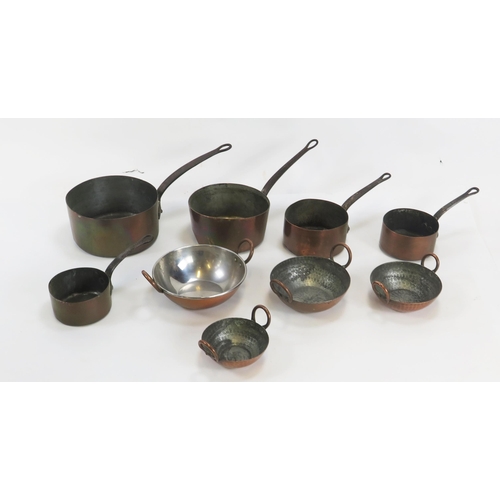 1294 - A set of five graduated copper saucepans, with steel loop handles together with four copper twin han... 