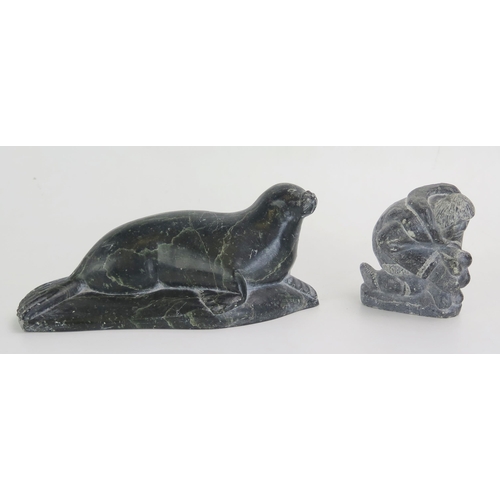 1612 - An Inuit carved hardstone model of a recumbent seal, with paper label to the base, 20cm long, togeth... 