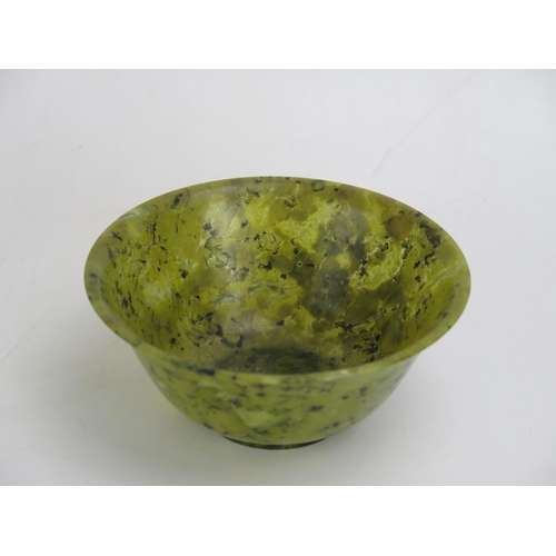 1627 - A Chinese jadeite bowl of plain circular form, on a circular foot, 13cm diameter.