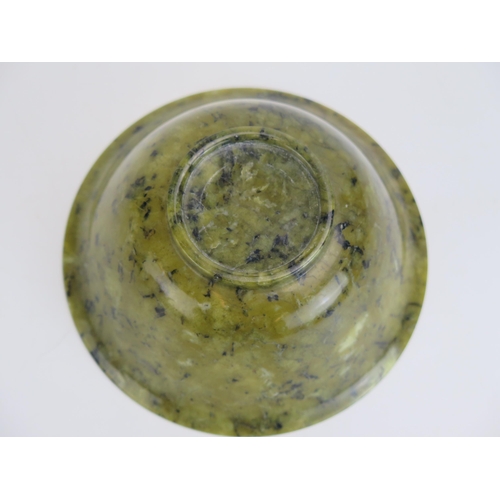 1627 - A Chinese jadeite bowl of plain circular form, on a circular foot, 13cm diameter.